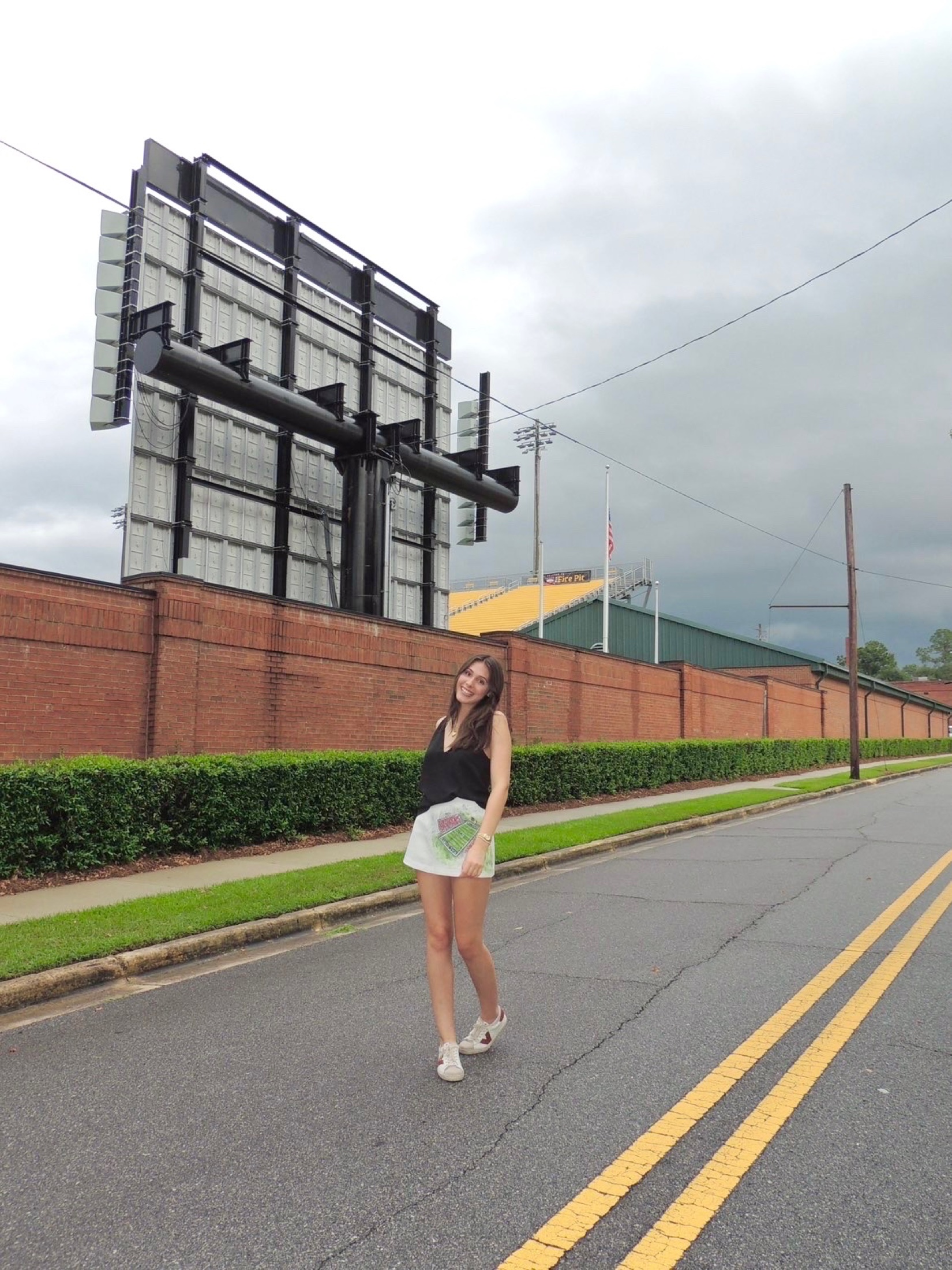 A model wearing a hand-painted collegiate skirt near a football stadium